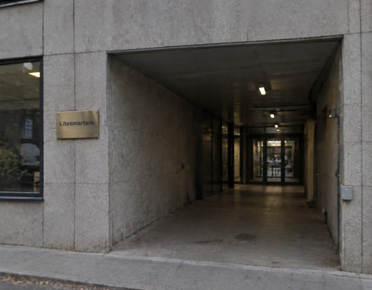 Entrén till Litesmartares kontor med mässingskylt på stenfasad