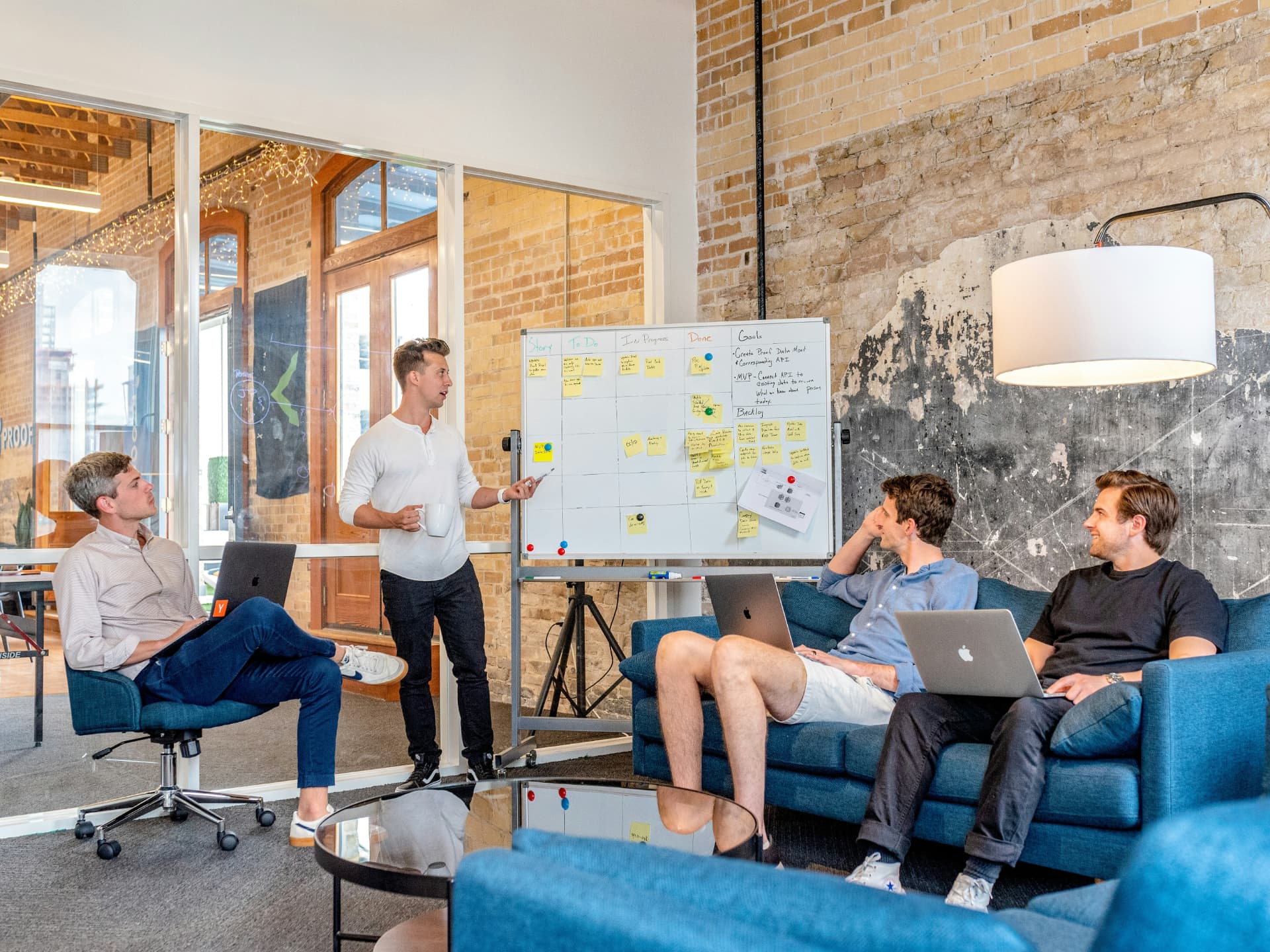 Ett team som arbetar tillsammans framför en whiteboard med planering i en modern kontorsmiljö