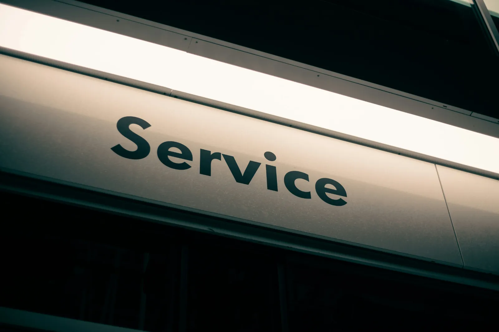Upplyst serviceskylt på en modern byggnad